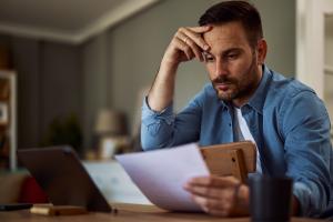 A worried individual reviewing a divorce petition document at home, with a family lawyer's support.